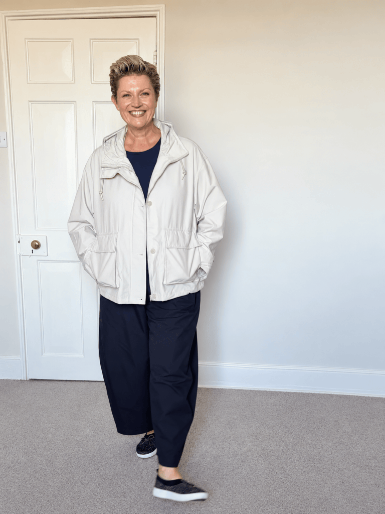 Susy wearing a light neutral Uniqlo autumn jacket over a navy top with black trousers